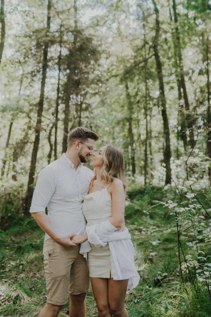 A couple sharing a tender moment in the forest during their Couple Photoshoot.